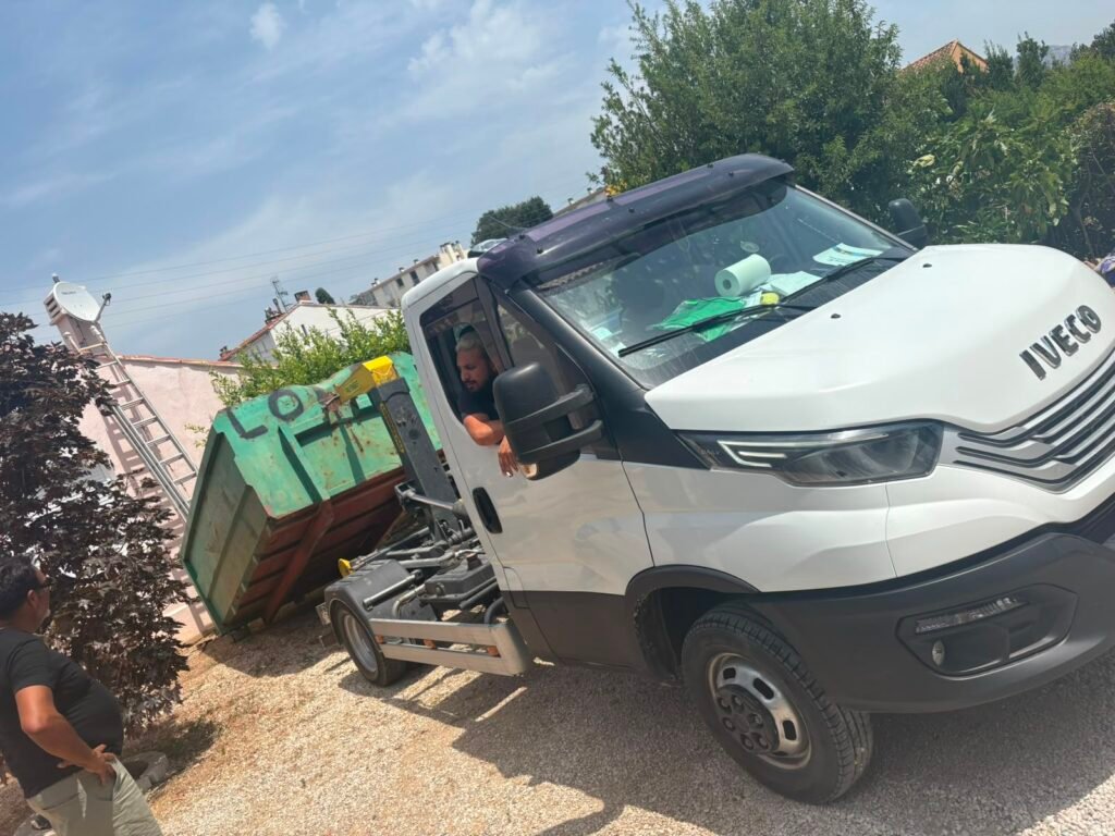Petite benne posée devant une maison